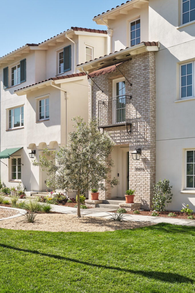 Front elevation of a Marabel townhome with stone accents and green lawn in Newark, CA