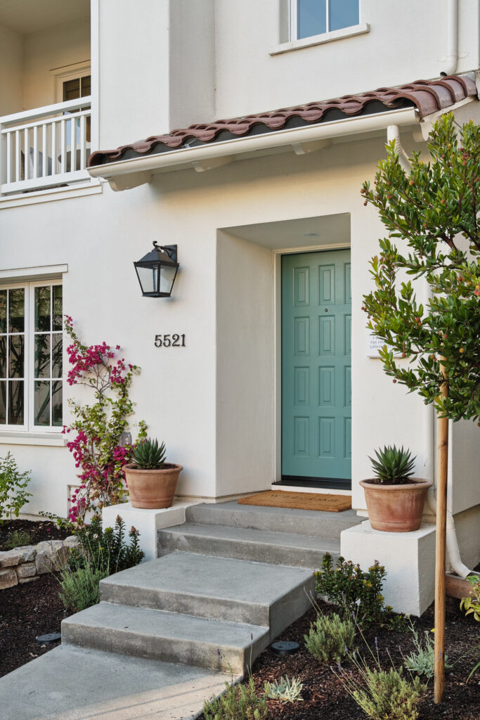 Teal front door and balcony at a Marabel townhome entrance in Newark, CA