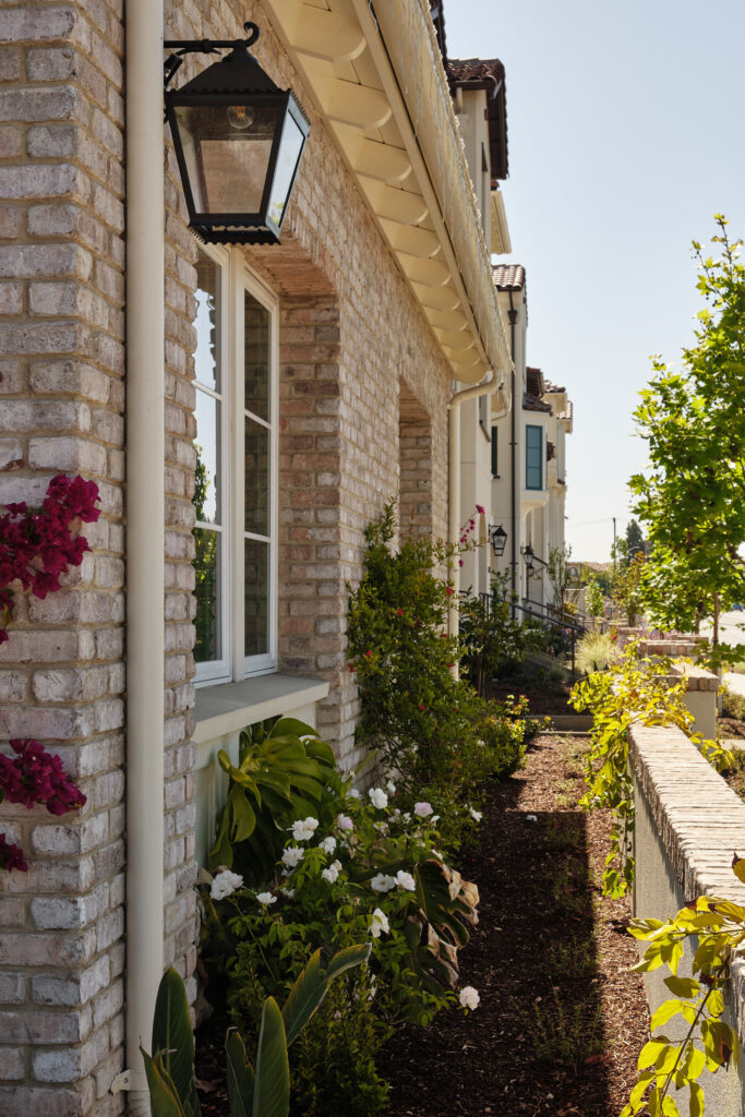 Flower-lined walkway along a brick facade at Marabel in Newark, CA